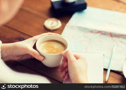 vacation, tourism, travel, destination and people concept - close up of hands with coffee cup and travel stuff. close up of hands with coffee cup and travel stuff