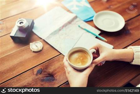 vacation, tourism, travel, destination and people concept - close up of hands with coffee cup and travel stuff. close up of hands with coffee cup and travel stuff