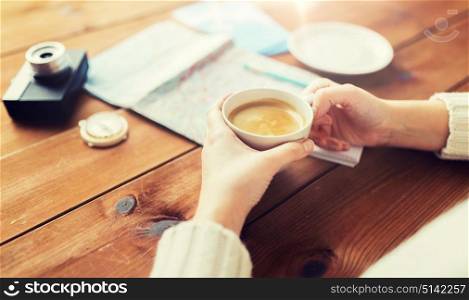 vacation, tourism, travel, destination and people concept - close up of hands with coffee cup and travel stuff. close up of hands with coffee cup and travel stuff