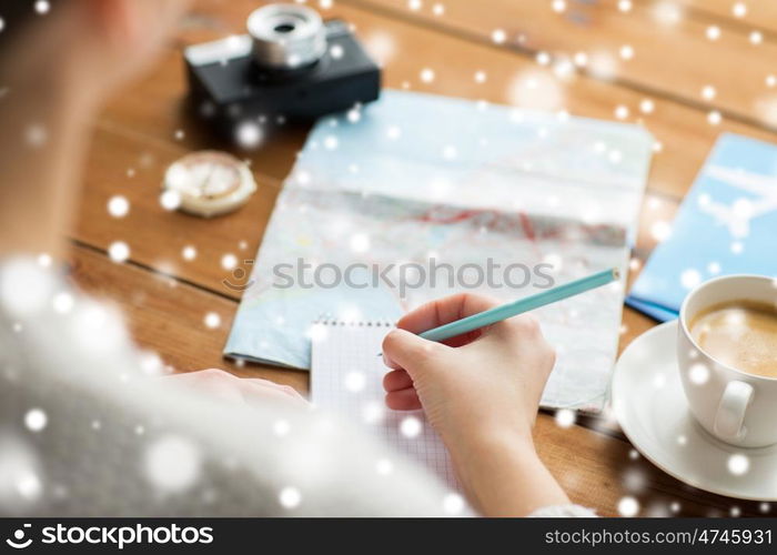 vacation, tourism, travel, destination and people concept - close up of traveler hands with blank notepad and pencil