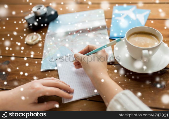 vacation, tourism, travel, destination and people concept - close up of traveler hands with blank notepad and pencil