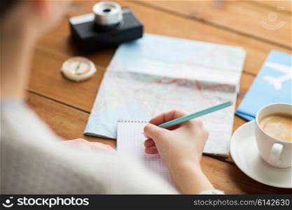 vacation, tourism, travel, destination and people concept - close up of traveler hands with blank notepad and pencil