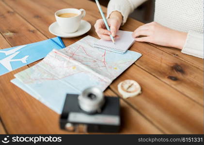 vacation, tourism, travel, destination and people concept - close up of traveler hands with blank notepad and pencil