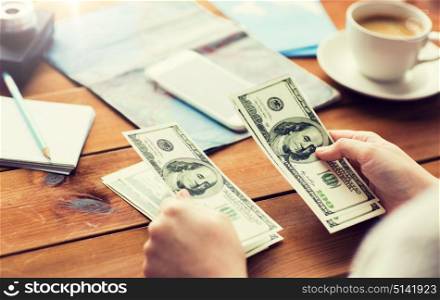 vacation, tourism, travel, finances and people concept - close up of traveler hands counting dollar cash money. close up of traveler hands counting dollar money