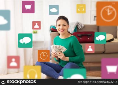 vacation, tourism, travel, finances and people concept - happy young woman with money and bag at home over multimedia icons. happy woman with money and travel bag at home