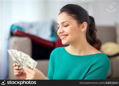 vacation, tourism, travel, finances and people concept - happy young woman with money at home