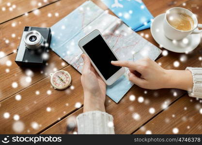 vacation, tourism, travel, technology and people concept - close up of traveler hands with blank smartphone screen and map