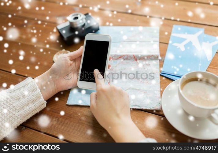 vacation, tourism, travel, technology and people concept - close up of traveler hands with blank smartphone screen and map