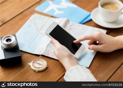 vacation, tourism, travel, technology and people concept - close up of traveler hands with blank smartphone screen and map
