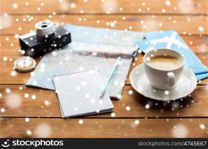 vacation, tourism, travel, winter holidays and objects concept - close up of blank notepad with map, coffee and airplane tickets