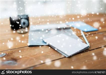 vacation, tourism, travel, winter holidays and objects concept - close up of blank notepad with map and airplane tickets