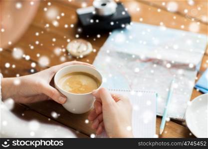 vacation, tourism, travel, winter holidays and people concept - close up of hands with coffee cup and map