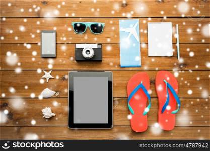 vacation, tourism, winter holidays and objects concept - close up of tablet pc computer and travel stuff