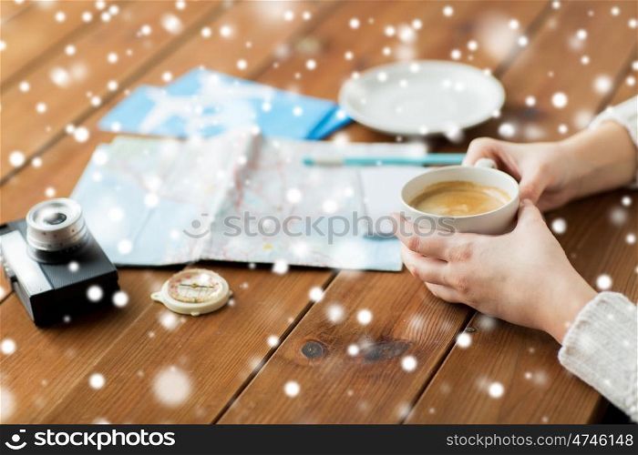 vacation, tourism, winter holidays and people concept - hands with coffee cup and travel stuff