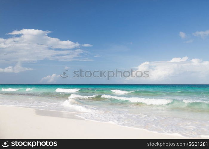 vacation, travel and background concept - blue sea or ocean, white sand and sky with clouds