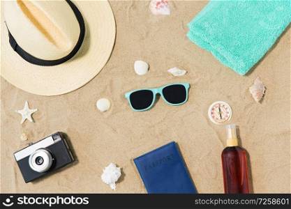 vacation, travel and tourism concept - vintage camera, passport, hat and sunglasses on beach sand. camera, passport, sunglasses and hat on beach sand