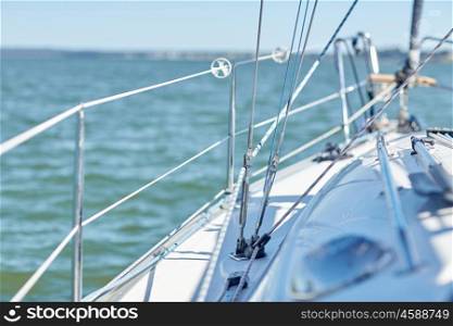 vacation, travel, cruise and yachting concept - close up of cable on sailboat or sailing yacht deck and sea