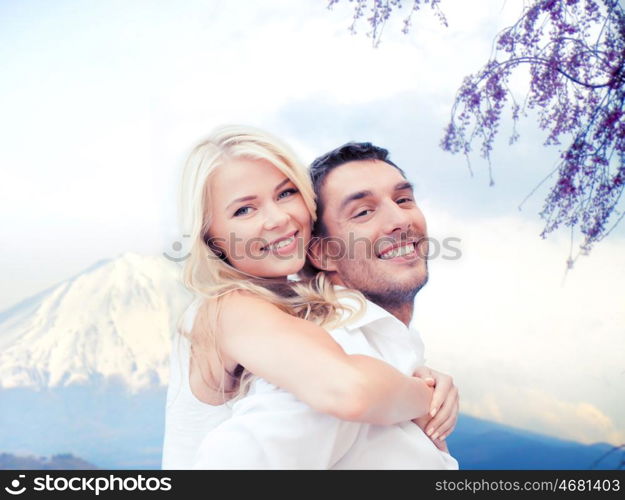 vacation, travel, honeymoon, people and tourism concept - happy couple having fun over fuji mountain background