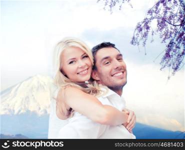 vacation, travel, honeymoon, people and tourism concept - happy couple having fun over fuji mountain background