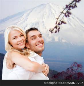 vacation, travel, honeymoon, people and tourism concept - happy couple having fun over japan mountains background
