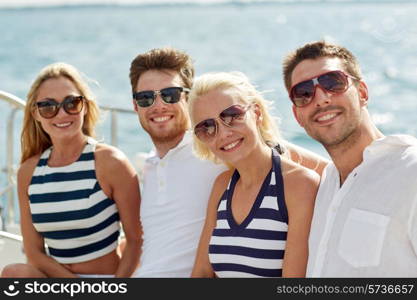 vacation, travel, sea, friendship and people concept - smiling friends sitting and talking on yacht deck