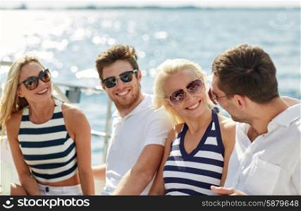vacation, travel, sea, friendship and people concept - smiling friends sitting and talking on yacht deck