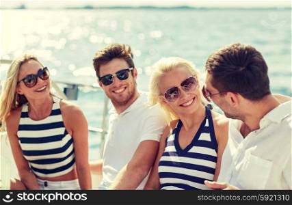 vacation, travel, sea, friendship and people concept - smiling friends sitting and talking on yacht deck