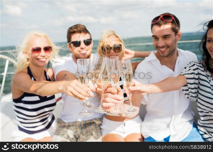 vacation, travel, sea, holidays and people concept - close up of happy friends clinking glasses of champagne and sailing on yacht