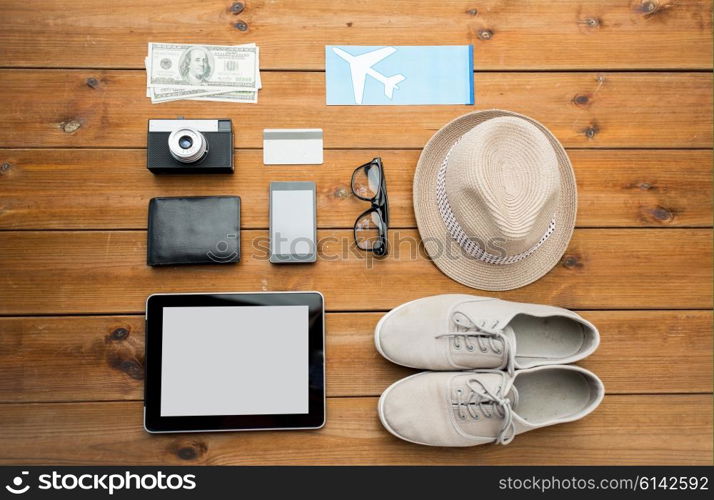 vacation, travel, tourism, technology and objects concept - close up of gadgets and traveler personal stuff