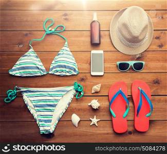 vacation, travel, tourism, technology and objects concept - close up of smartphone and beach stuff. close up of smartphone and beach stuff. close up of smartphone and beach stuff