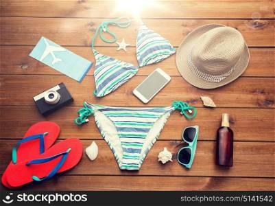 vacation, travel, tourism, technology and objects concept - close up of smartphone and beach stuff. close up of smartphone and beach stuff