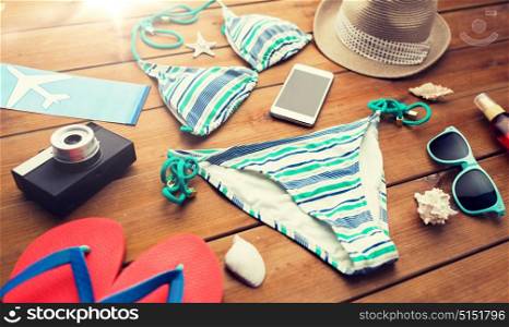 vacation, travel, tourism, technology and objects concept - close up of smartphone and beach stuff. close up of smartphone and beach stuff