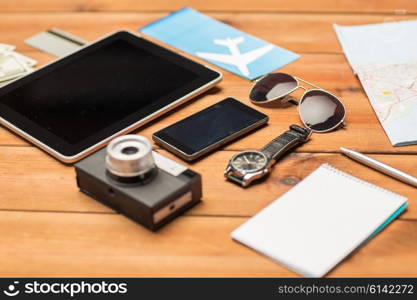 vacation, travel, tourism, technology and objects concept - close up of smartphone and personal stuff
