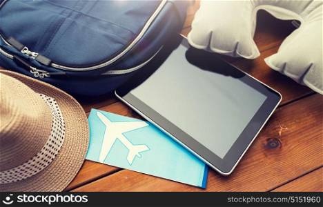 vacation, travel, tourism, technology and objects concept - close up of tablet pc computer and traveler personal stuff. close up of tablet pc and traveler personal stuff