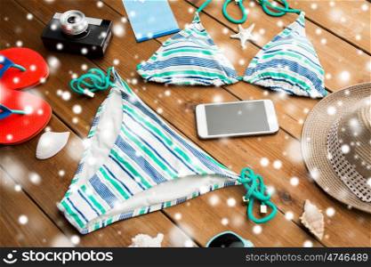 vacation, travel, tourism, winter holidays and objects concept - close up of smartphone and beach stuff