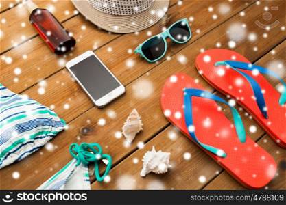 vacation, travel, tourism, winter holidays and objects concept - smartphone and beach stuff