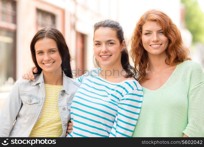 vacation, weekend, leisure and friendship concept - smiling teenage girls on street