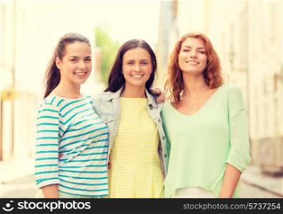 vacation, weekend, leisure and friendship concept - smiling teenage girls on street