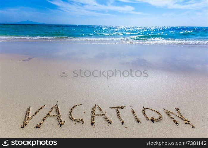 Vacation word writing on tropical sea beach. Vacation writing on a beach