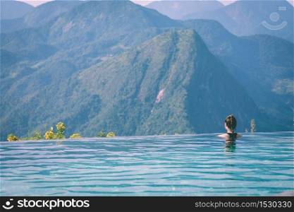 Vacations of Woman relax in tropical infinity pool above the Mountain peak in the morning in front of beautiful nature views in SAPA vietnam,Feel so Happiness and comfortable in holidays