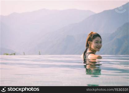 Vacations of Woman relax in tropical infinity pool above the Mountain peak in the morning in front of beautiful nature views in SAPA vietnam,Feel so Happiness and comfortable in holidays