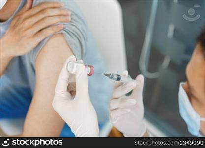 Vaccination concept, Male doctor preparing vaccine against covid-19 to injecting for male patient.