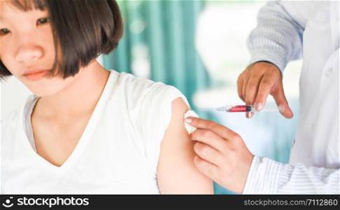 Vaccination of children by injection needle nurses are vaccinations to patients using the syringe in hospital / Doctor giving patient vaccine in arm of asian child girl healthy and medical concept