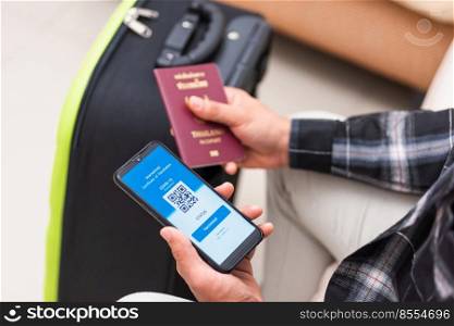 Vaccination passport, Traveler man holding health passport of vaccination certification on smartphone app at airport before boarding plane during coronavirus pandemic, Mobile app of virus COVID-19