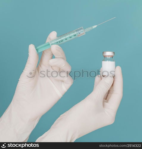 vaccine bottle syringe held by hands with gloves