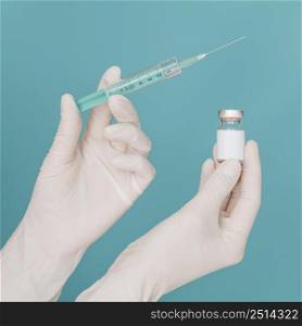 vaccine bottle syringe held by hands with gloves