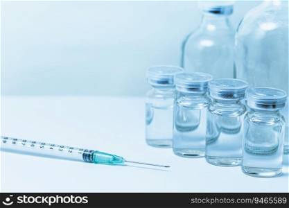Vaccine bottle with syringe injection medical needle with space for text blue color tone.