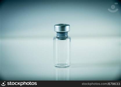 Vaccine glass bottle on a grey background. Vaccine bottle on grey background