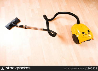 Vacuum cleaner on the polished wooden floor