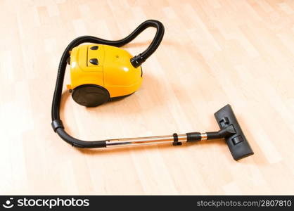 Vacuum cleaner on the polished wooden floor